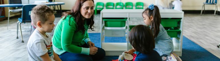 Teacher smiling at young students
