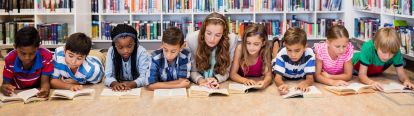 students lying on the floor reading with the teacher
