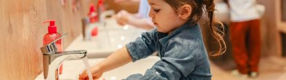 Young girl washing her hands in a sink