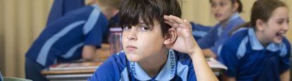 Boy holding his ear to listen