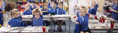 Students raising their hands in class