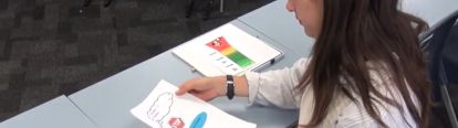 Teacher looking at sheets with visuals on them